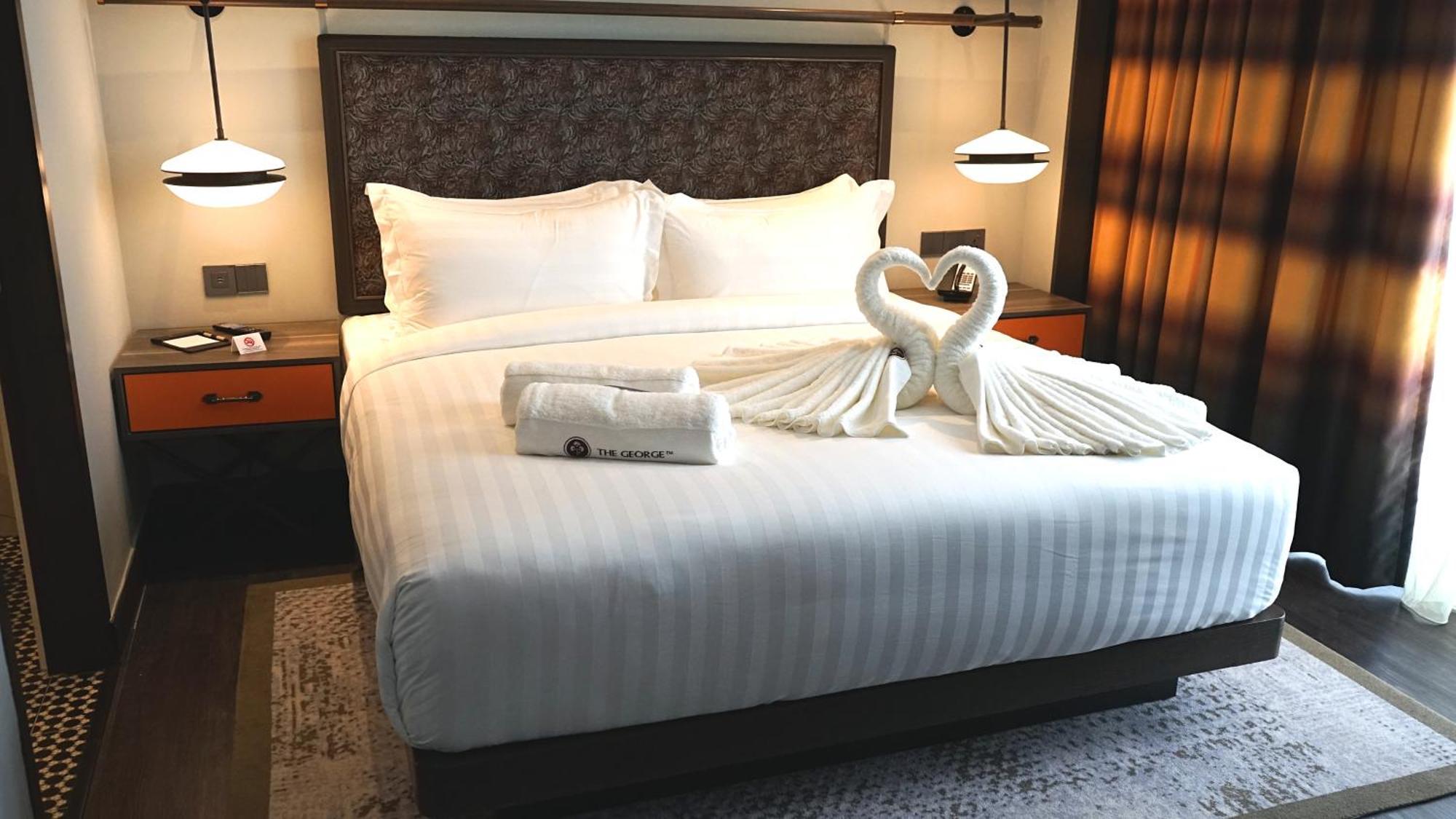 The George Penang By The Crest Collection Hotell George Town Exteriör bild A bed with a swan shaped towel